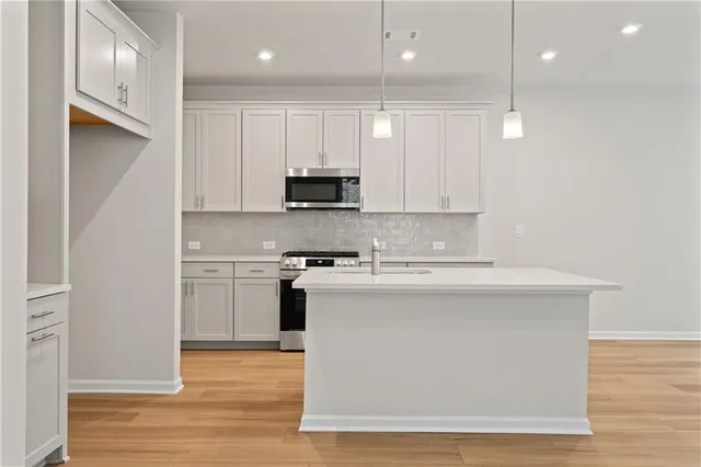 a kitchen with kitchen island a sink stainless steel appliances and cabinets