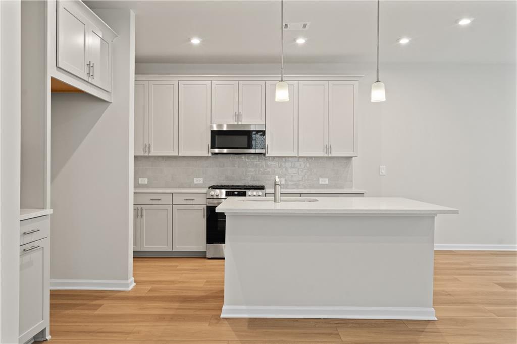 710 Smokey Quartz Way Kennesaw, GA 30144 - Photo 9 of 31 a kitchen with kitchen island a sink stainless steel appliances and cabinets