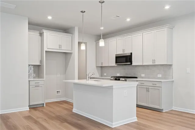 a kitchen with stainless steel appliances granite countertop a stove a sink and a refrigerator