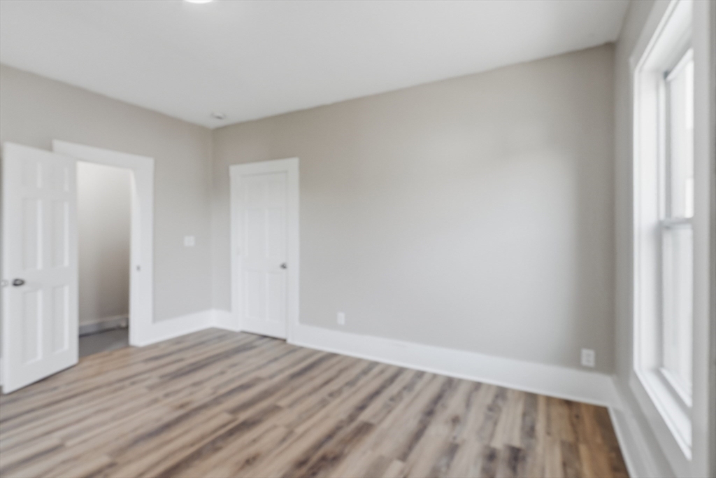 834 Worthington Street, Unit 2 Springfield, MA 01105 - Photo 12 of 20 a view of an empty room with wooden floor and a window