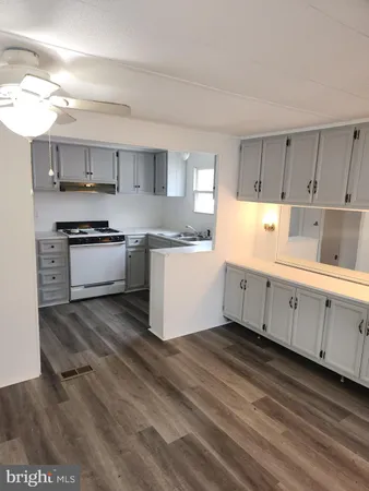 a kitchen with stainless steel appliances granite countertop a stove a sink and white cabinets