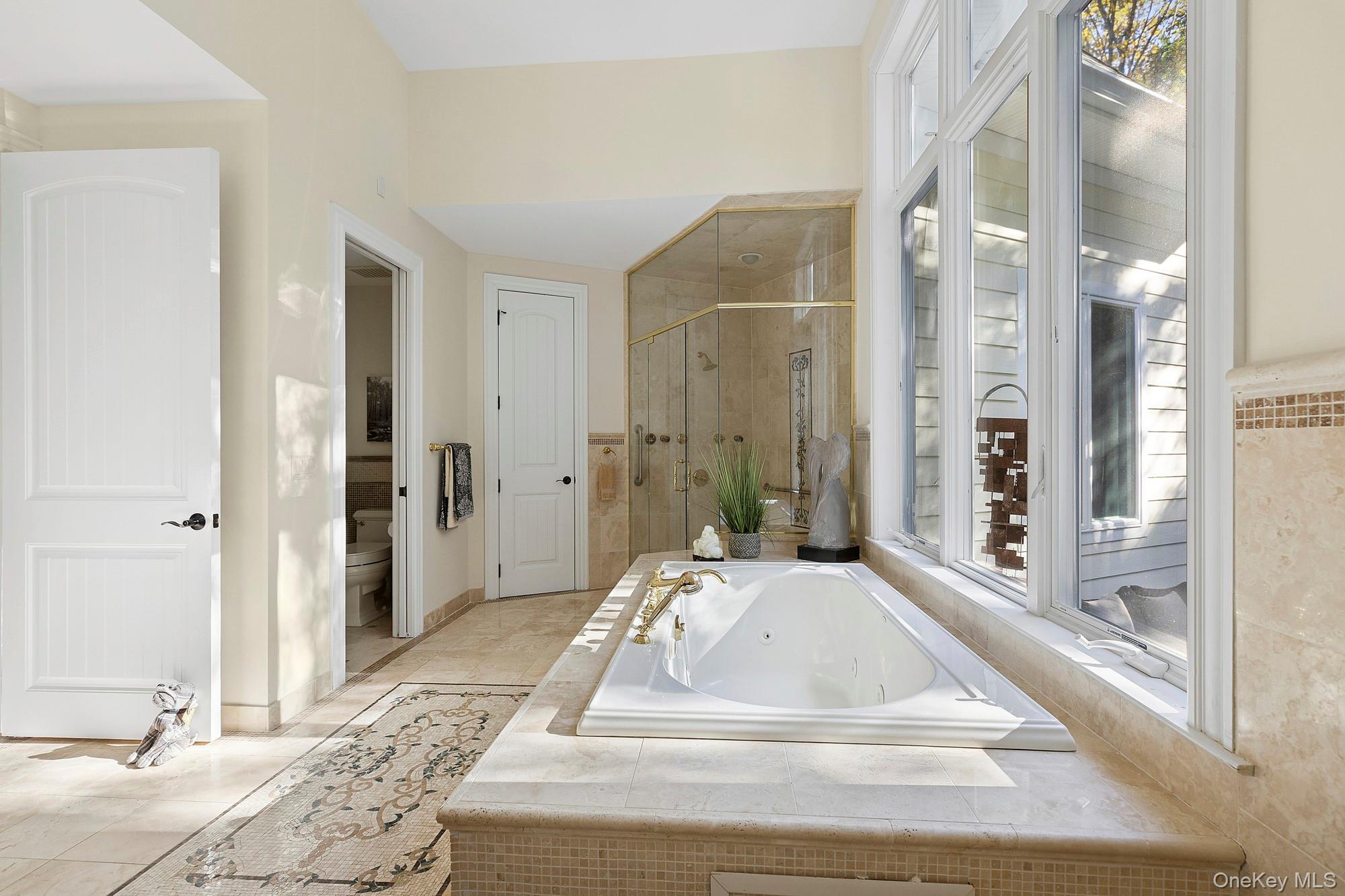 144 Round Swamp Road West Hills, NY 11743 - Photo 25 of 39 Bathroom featuring a tub with jets, a stall shower, and light tile patterned flooring