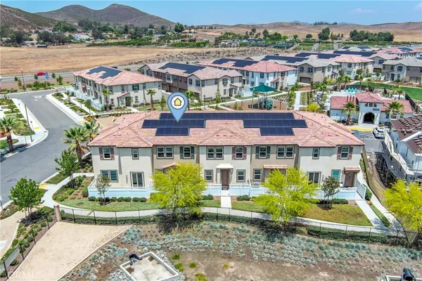 a front view of a house with a garden and lake view