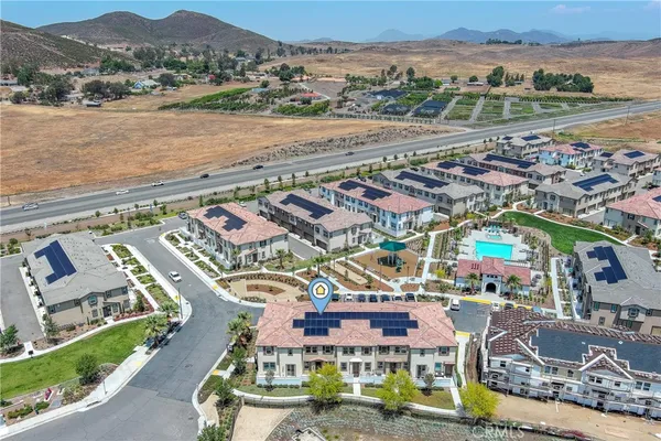 an aerial view of residential houses with outdoor space and ocean view