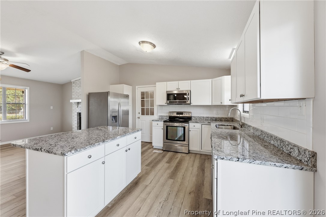1304 Chara Court Spring Lake, NC 28390 - Photo 14 of 33 a kitchen with stainless steel appliances granite countertop a stove top oven a sink and white cabinets