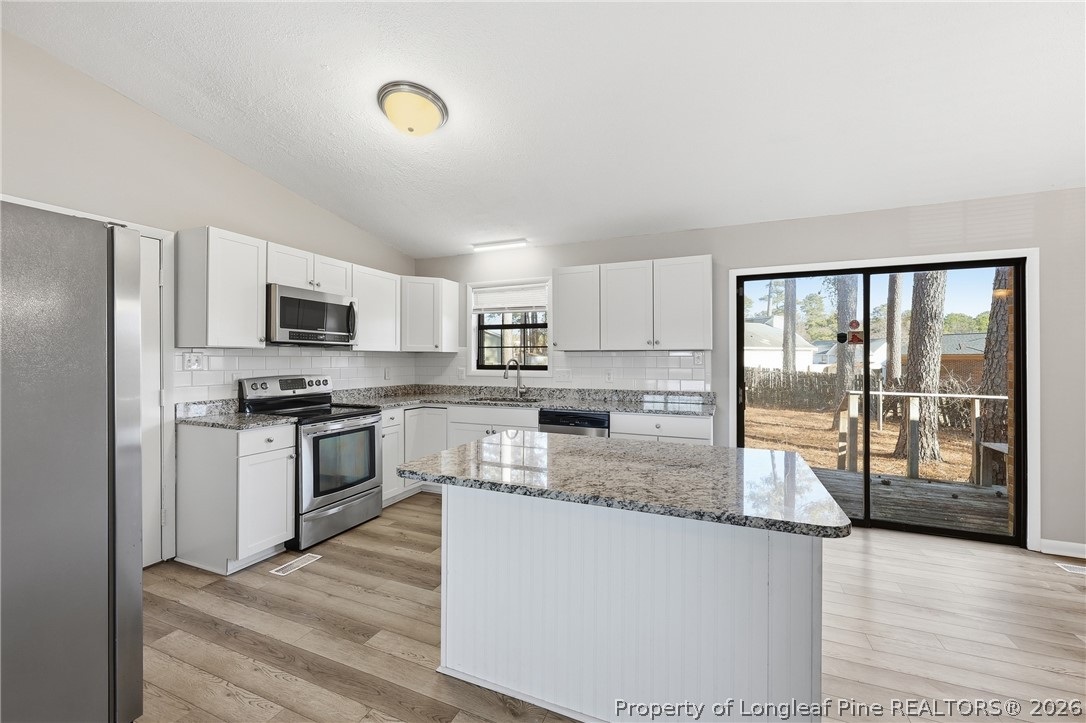 1304 Chara Court Spring Lake, NC 28390 - Photo 15 of 33 a kitchen with stainless steel appliances granite countertop a refrigerator a stove top oven a sink and dishwasher
