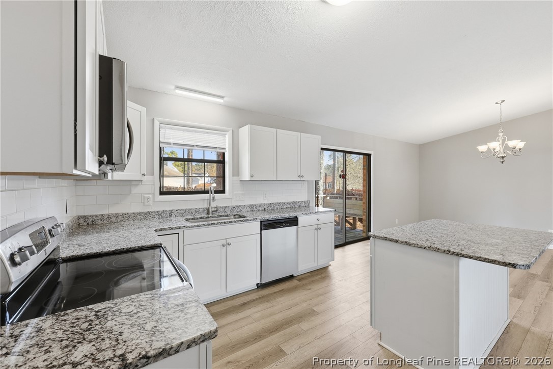 1304 Chara Court Spring Lake, NC 28390 - Photo 16 of 33 a kitchen with granite countertop a sink stove and cabinets