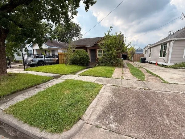 a front view of a house with a yard and potted plants