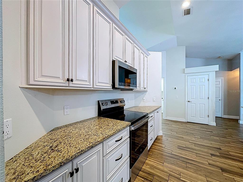 18812 Bascomb Lane Hudson, FL 34667 - Photo 31 of 57 a kitchen with stainless steel appliances granite countertop a stove a sink and a microwave