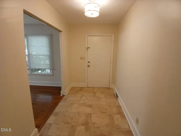 a view of hallway with wooden floor and mirror