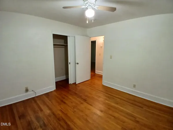 a view of an empty room with wooden floor