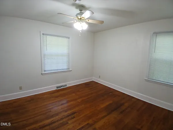 a view of a room with wooden floor and a window
