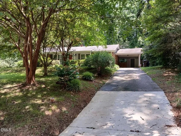 a front view of a house with a yard and potted plants