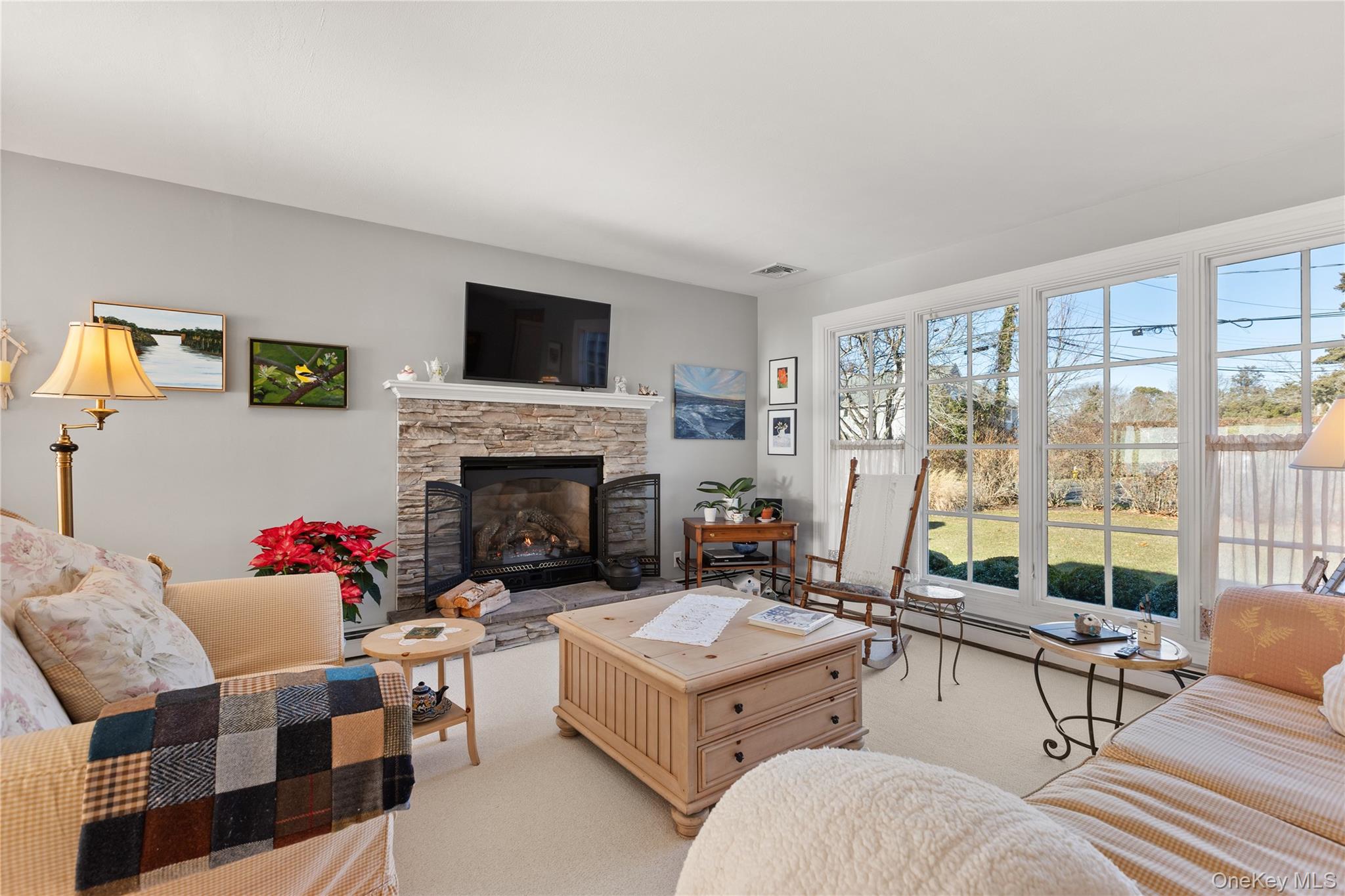 5 A Bay Road East Patchogue, NY 11772 - Photo 16 of 27 Carpeted living room featuring a stone fireplace