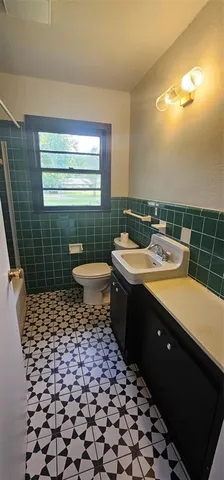 a bathroom with a sink toilet and window