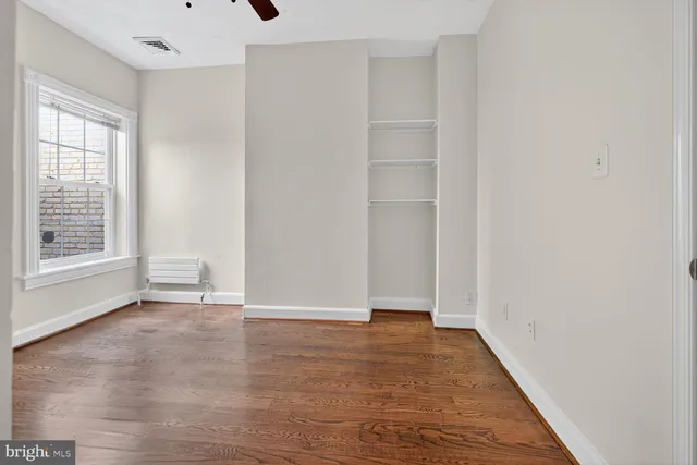 a view of an empty room with wooden floor