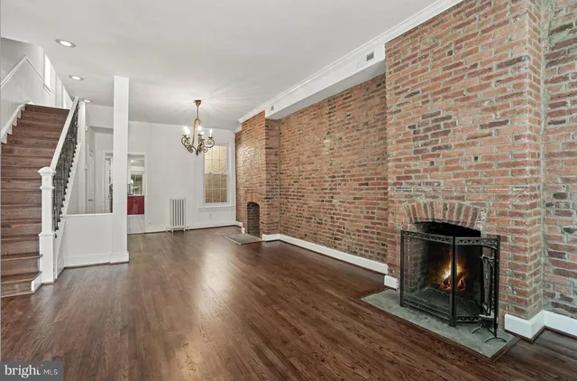 a view of empty room with wooden floor and fireplace