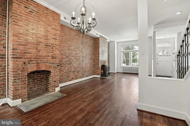 a view of empty room with wooden floor and fireplace