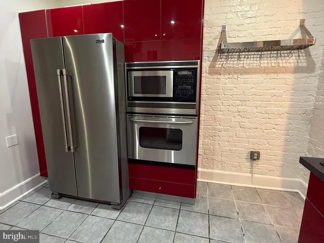 a kitchen with stainless steel appliances granite countertop a refrigerator and a stove