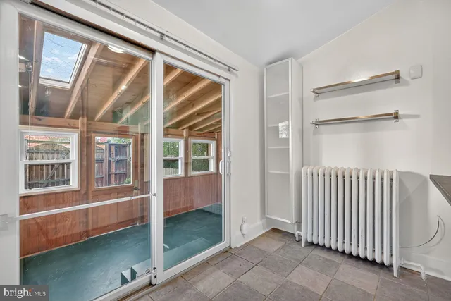 a view of an empty room with wooden floor and windows
