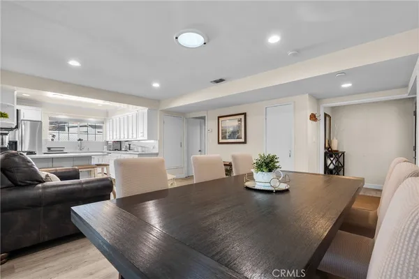 a living room with furniture and a dining table with kitchen view