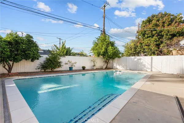 a view of a house with pool and chairs