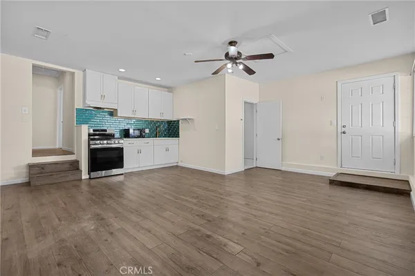 a kitchen with stainless steel appliances granite countertop a stove and a white cabinets