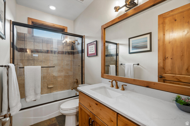 4892 Eagle Rdg Drive Eden, UT 84310 - Photo 15 of 39 Bathroom featuring a natural wood vanity with a white countertop and undermount sink, bronze-finish faucet, and a large wood-framed mirror