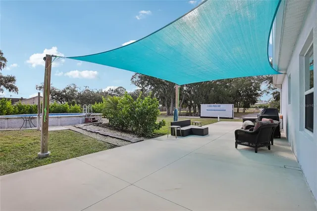 a view of a patio with a table and chairs under an umbrella