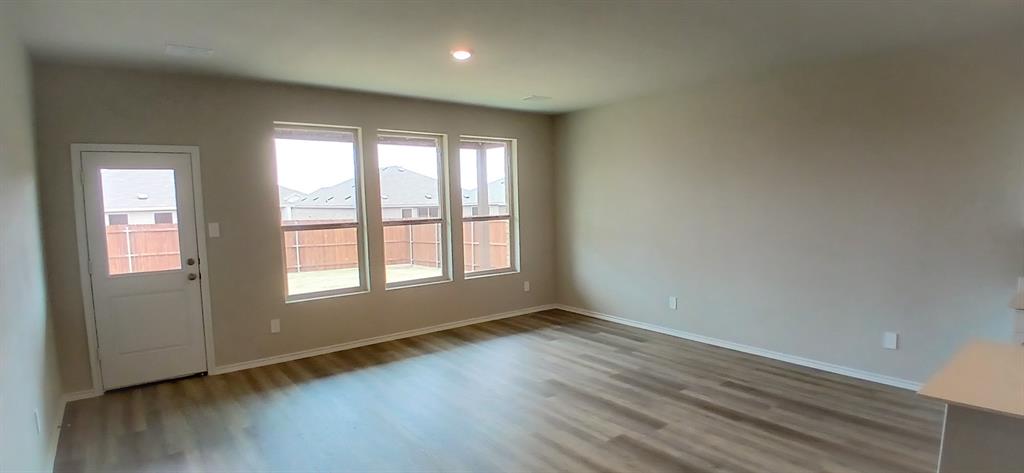 309 Potato Street Keene, TX 76059 - Photo 2 of 16 an empty room with wooden floor and windows