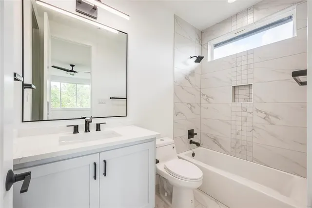 a bathroom with a sink a toilet a mirror and shower