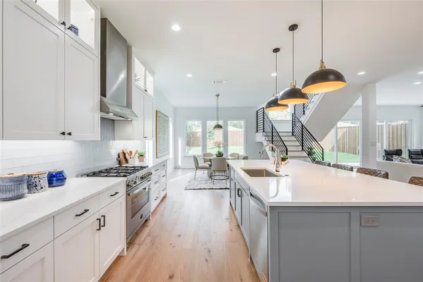 a kitchen with stove a sink and cabinets