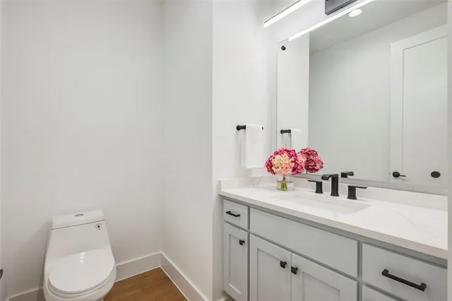 a bathroom with a sink vanity mirror and toilet