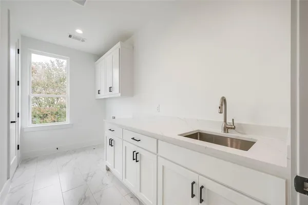 a kitchen with cabinets a sink and a window