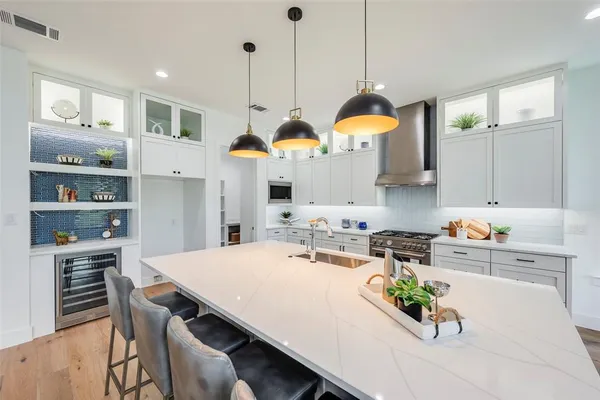 a kitchen with stainless steel appliances a dining table chairs and white cabinets