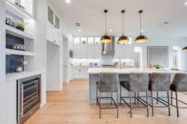 a kitchen with stainless steel appliances kitchen island granite countertop a stove a sink and a refrigerator