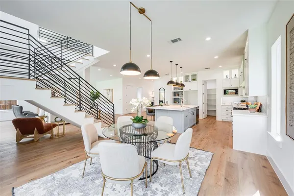a living room with furniture kitchen view and a wooden floor