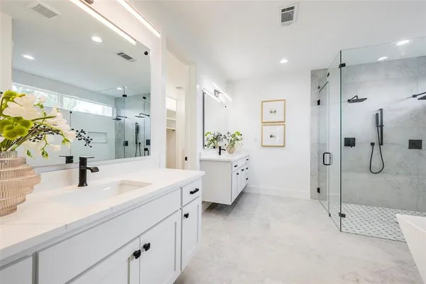 a bathroom with a shower sink vanity and mirror