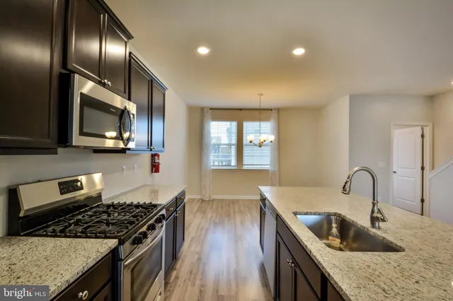 a kitchen with granite countertop stainless steel appliances window a sink and a stove