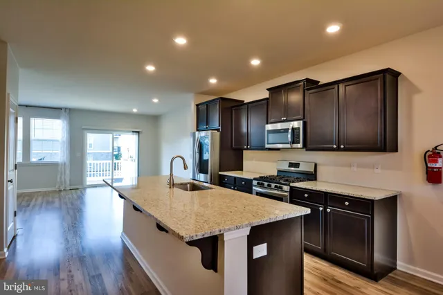 a kitchen with stainless steel appliances granite countertop wooden cabinets a stove top oven and granite counter tops