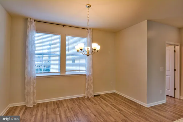 a view of a room with wooden floor and a window