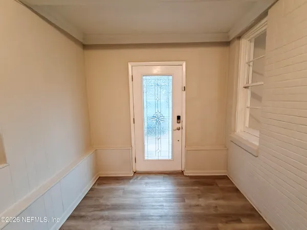 an empty room with wooden floor and windows