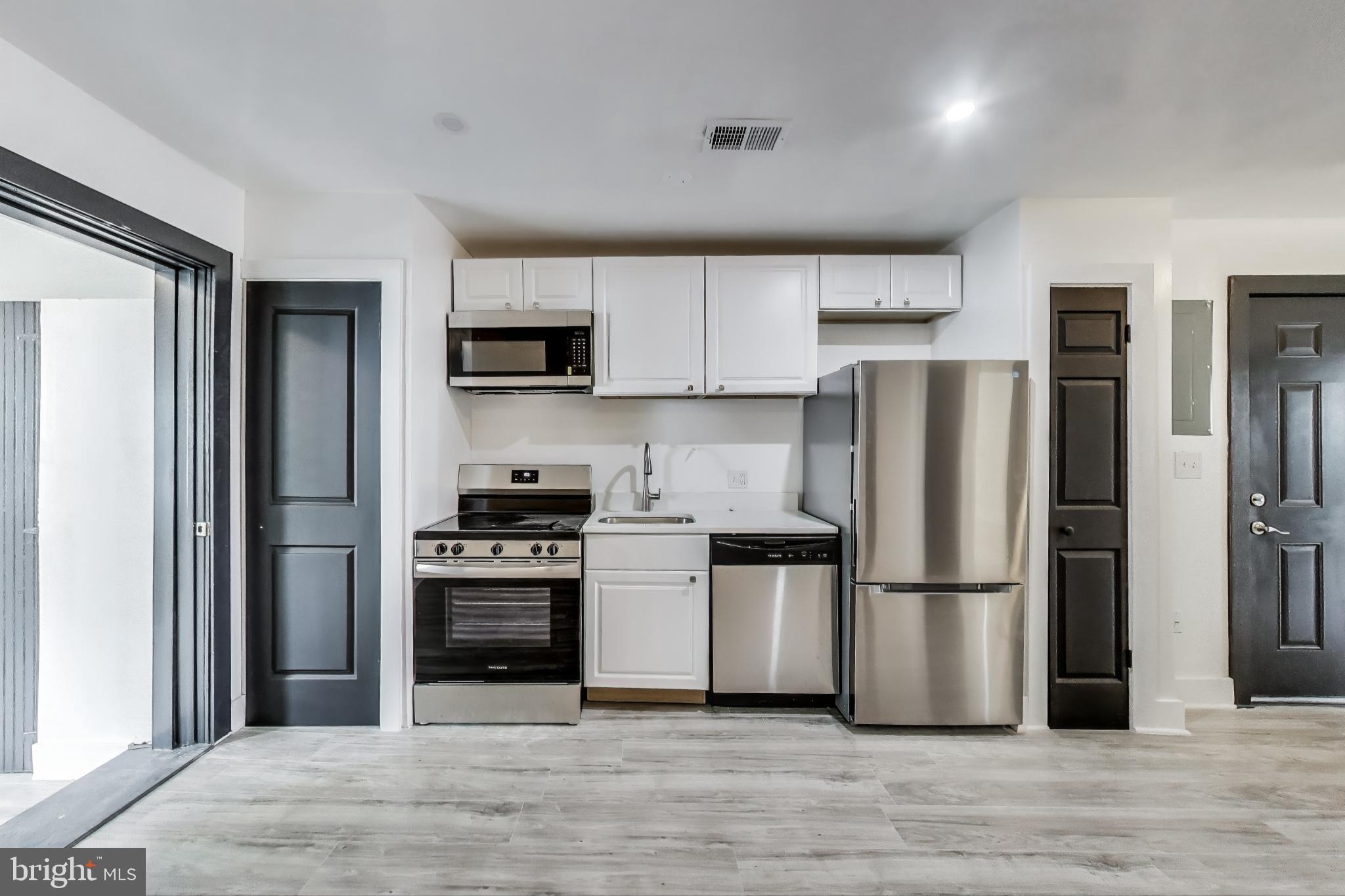 3918 10th Street Northeast, Unit 3 Washington, DC 20017 - Photo 40 of 69 a kitchen with a refrigerator stove and wooden cabinets