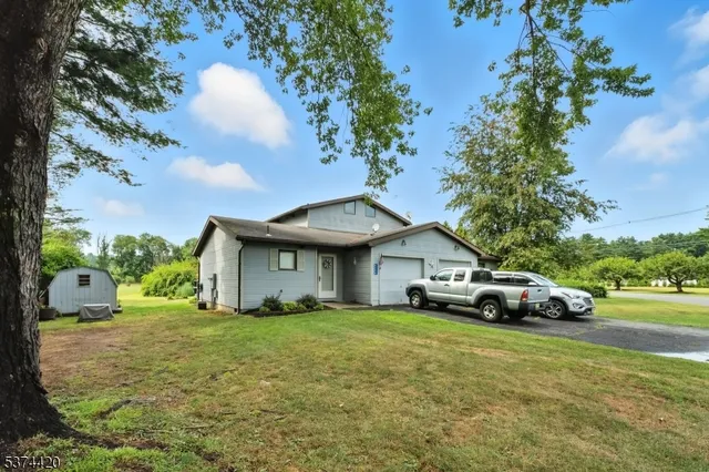 a white house covered with tall trees