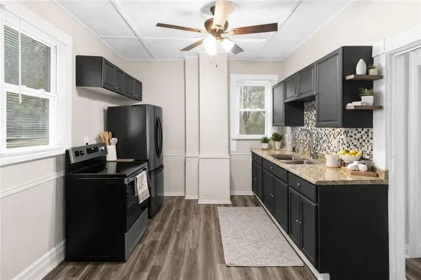 a kitchen with stainless steel appliances kitchen island granite countertop a refrigerator stove and sink