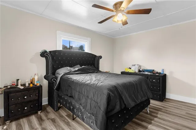 a bedroom with a bed and a chandelier fan