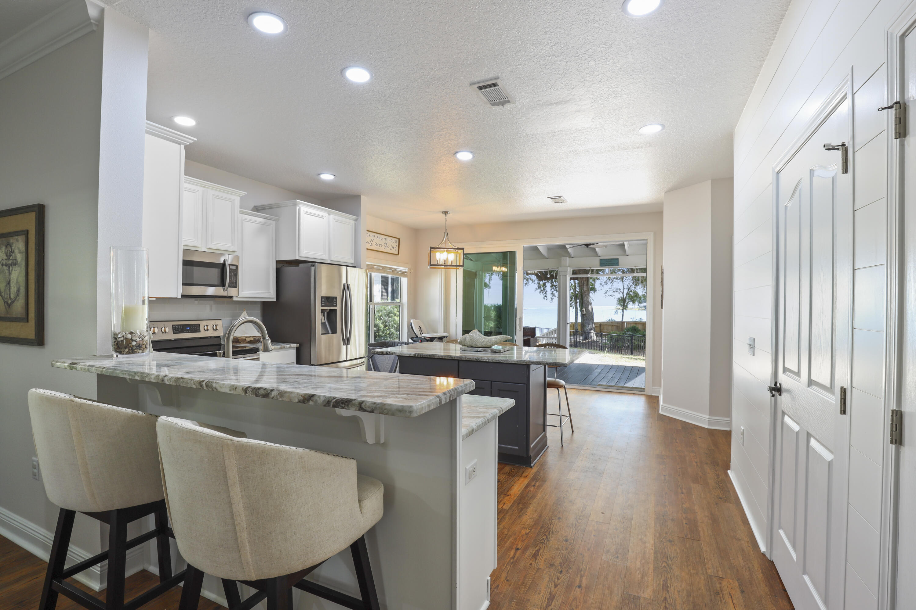 159 Beacon Point Drive Santa Rosa Beach, FL 32459 - Photo 8 of 57 a dining room with stainless steel appliances granite countertop furniture wooden floor a couch and a kitchen view