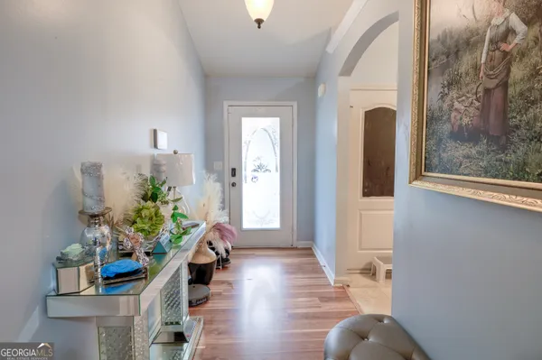a hallway with wooden floor and a potted plant