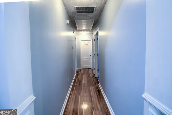 a view of a hallway with wooden floor