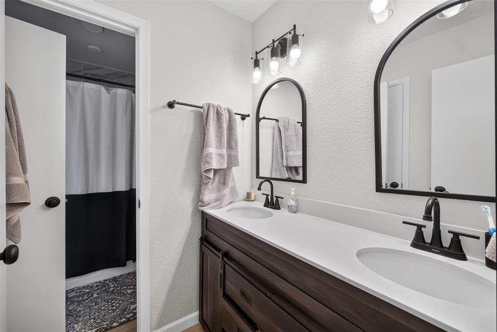3919 Ridgeoak Way Farmers Branch, TX 75244 - Photo 18 of 28 Double vanity with undermount sinks, black matte fixtures, and arched mirrors